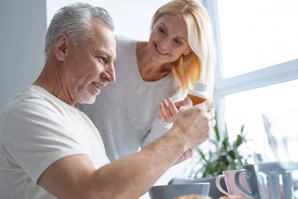 Pečující manželka nabízí vitamíny na svém manželovi stock fotografie — Stock fotografie