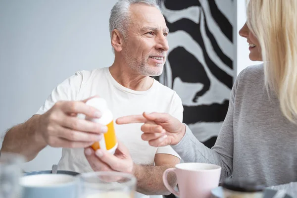 Glimlachende man en vrouw met medicijnen in handen stock foto — Stockfoto