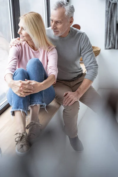 Hombre y mujer mirando por la ventana stock foto — Foto de Stock