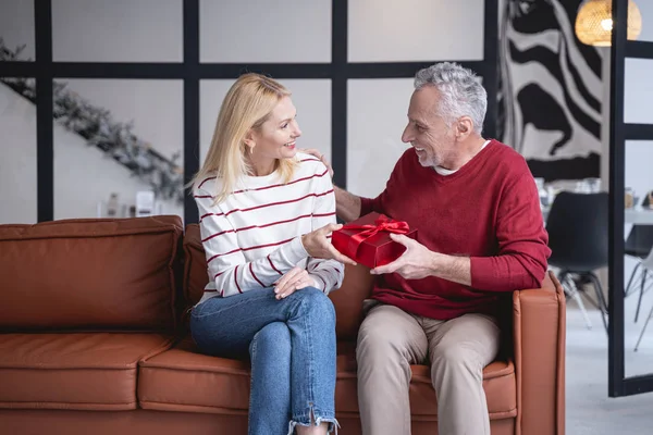 Couple ravi avec cadeau sur le canapé photo de stock — Photo