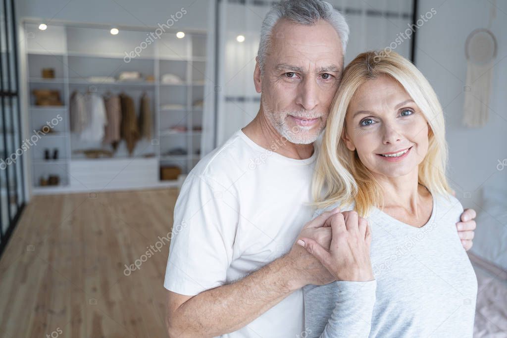 Smiling man with his woman in the bedroom stock photo