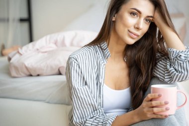 Kız dirseğini dizinde dinlendiriyor.