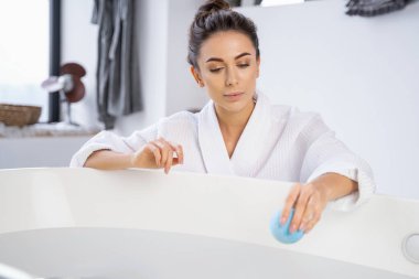 Banyo topuna bakan genç bir kadın.