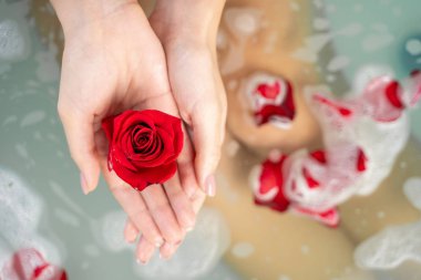 Beyaz bir bayan çiçek banyosu yapıyor.