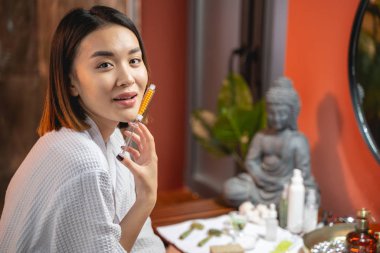 Güzel Asyalı bayan evde güzellik prosedürü uyguluyor.