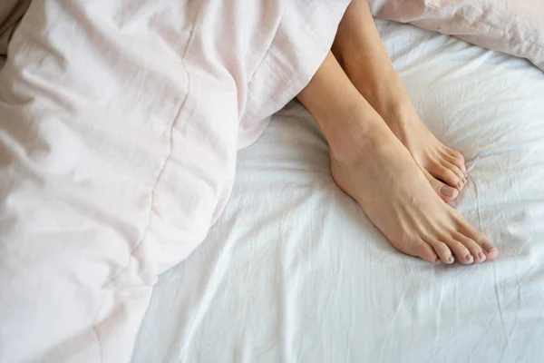 Женщина с босыми ногами отдыхает в постели — стоковое фото