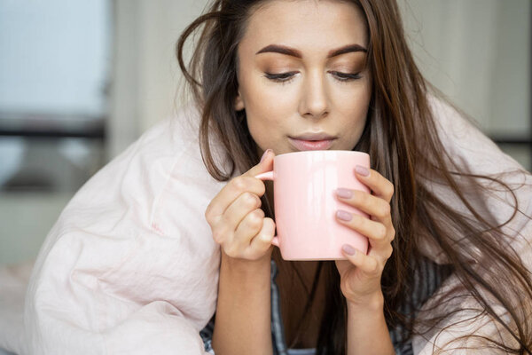 Pretty girl holding a cup with both hands