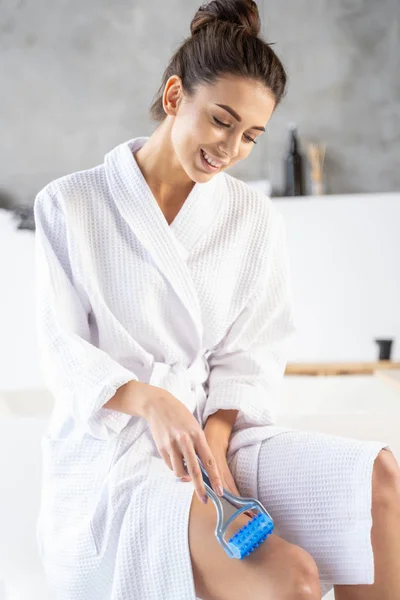 Girl in a bathrobe massaging her leg — 스톡 사진