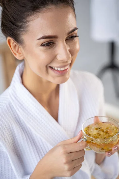 Mujer bonita sonriente con una bebida herbal —  Fotos de Stock