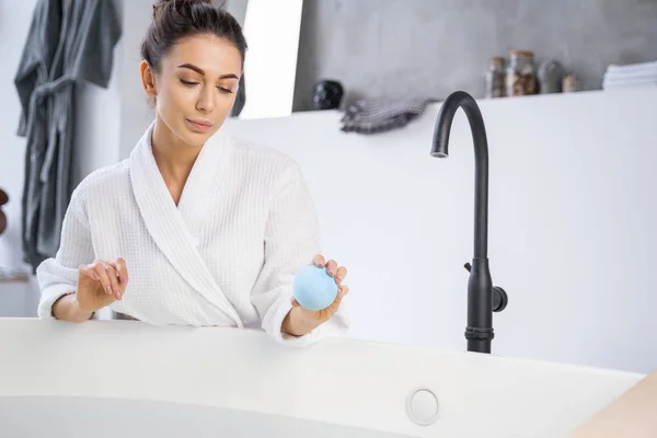 Serious young female looking at the bathwater — 스톡 사진