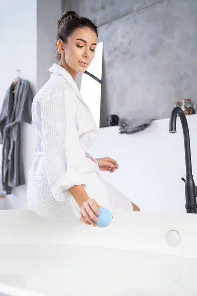 Serene lady sitting on the edge of a bathtub — Stock Photo, Image