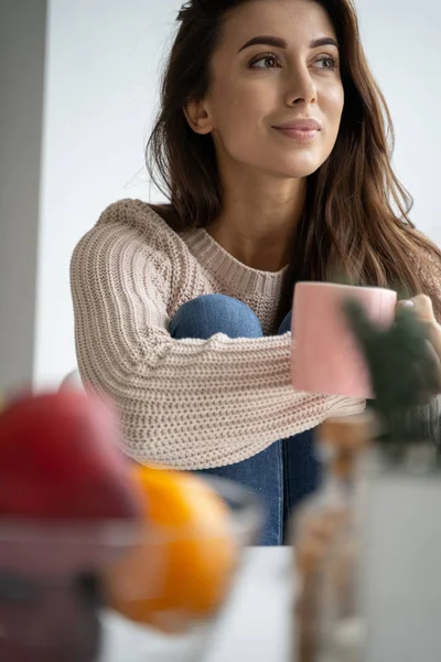 Kvinna med en kaffemugg som stirrar framåt — Stockfoto