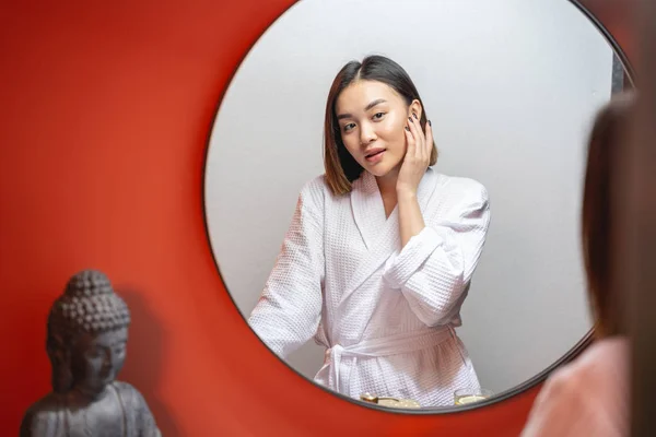 Linda chica asiática mirando el espejo en el interior —  Fotos de Stock