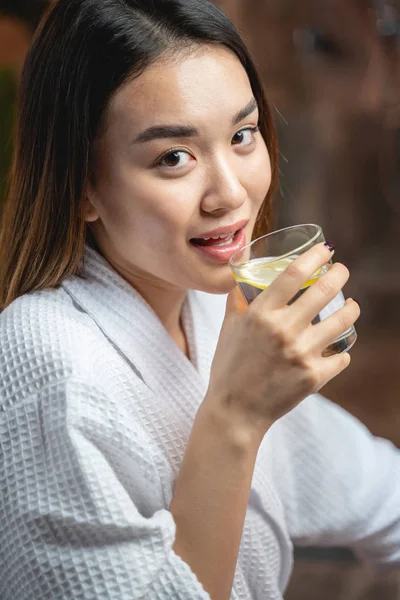 Söt charmig asiatisk dam dricka te efter skönhetsingrepp i salongen — Stockfoto