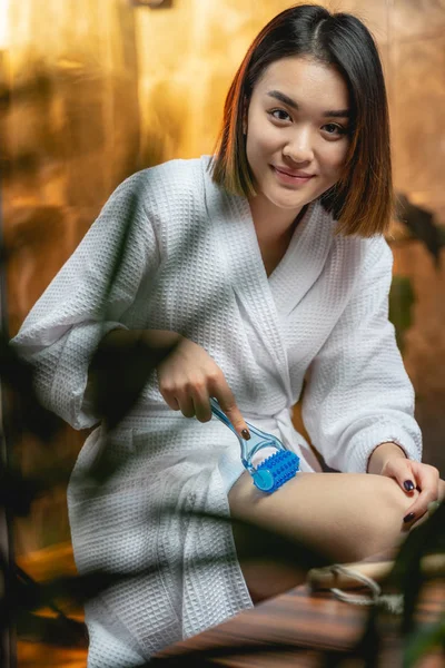 Sexy agradable dama haciendo masaje para las piernas con masajeador en el interior —  Fotos de Stock