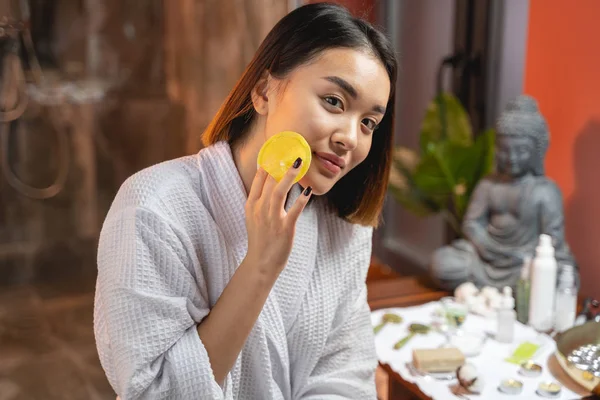 Hermosa señora asiática limpiando su cara con esponja —  Fotos de Stock