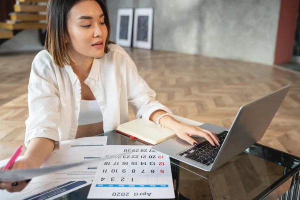 Asiatische Geschäftsfrau arbeitet mit Papieren und Laptop — Stockfoto