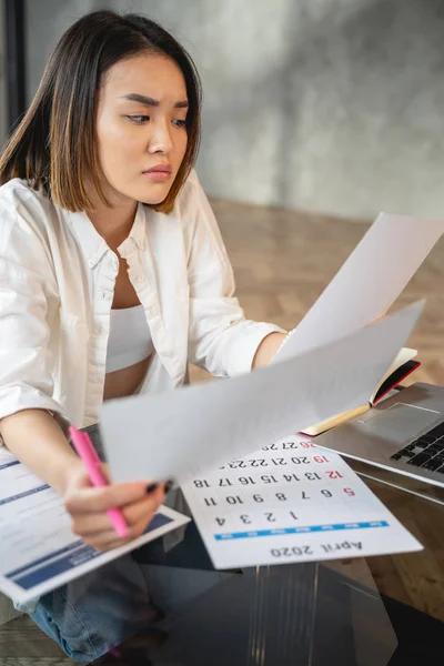 Asiatische junge Frau arbeitet mit Papieren im Haus — Stockfoto