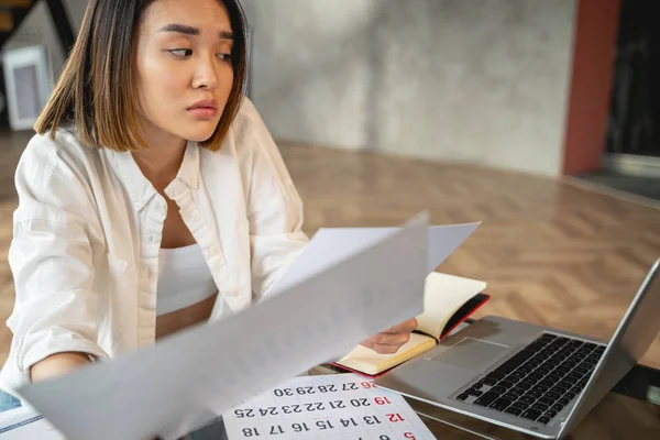 Asiatische charmante Frau arbeitet mit Papieren und Laptop — Stockfoto