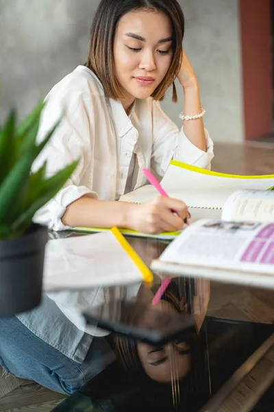 Umtriebige junge Frau arbeitet mit Papieren und Laptop — Stockfoto