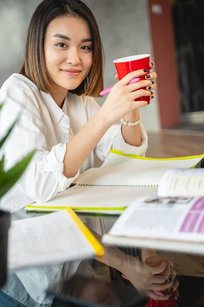 Asian young woman is drinking tea indoors — 스톡 사진