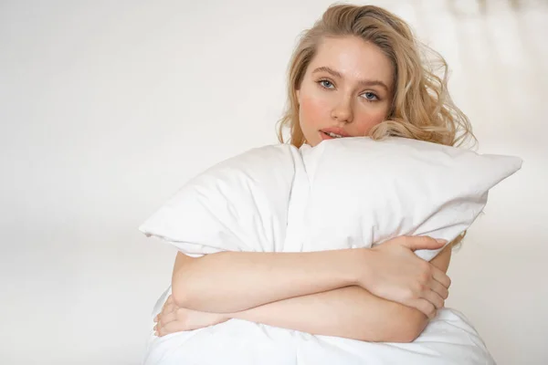 Retrato de una linda mujer joven que sostiene la almohada —  Fotos de Stock