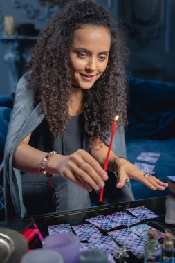 Güler yüzlü kahin yanan bir mum konik kullanıyor.