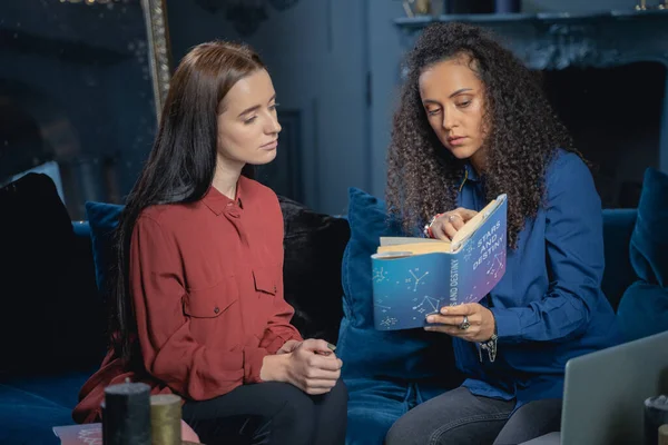 Serious young astrologer addressing her female client — Stock Photo, Image