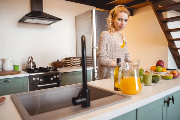 Atractiva joven hembra preparando batido verde — Foto de Stock