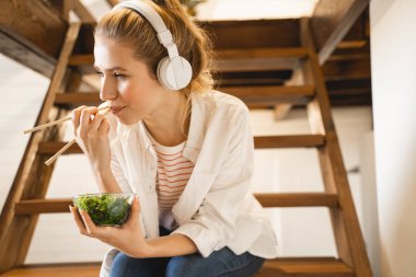 Positive delighted blonde girl eating green algae
