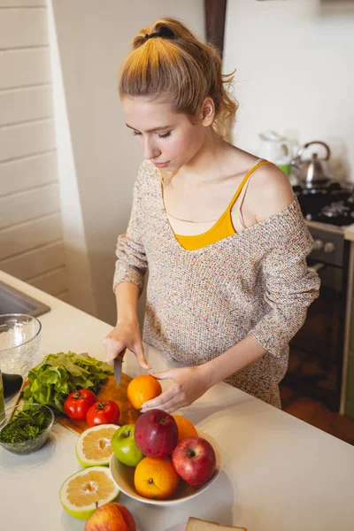 Концентрированная молодая женщина готовит здоровый ужин — стоковое фото