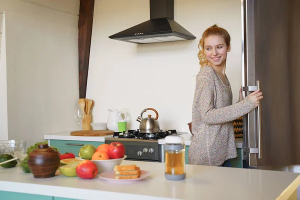 Positive delighted young woman looking at the table — Stock Photo, Image