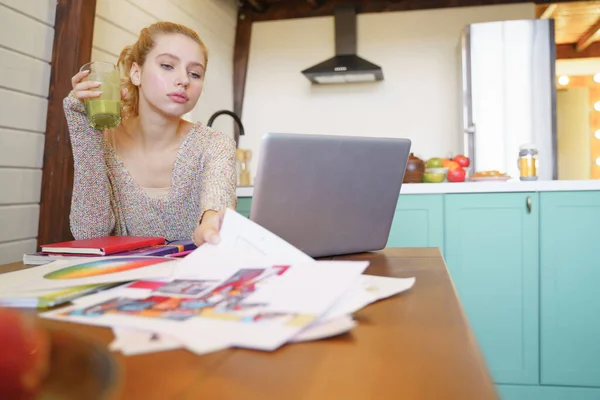 Cute blonde girl looking at her sketches — Stock Photo, Image