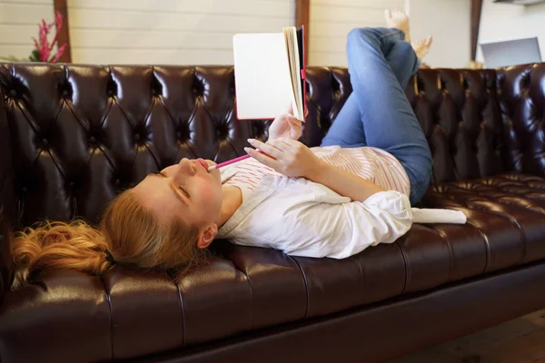 Charming young blonde lying on her cozy sofa — Stock Photo, Image