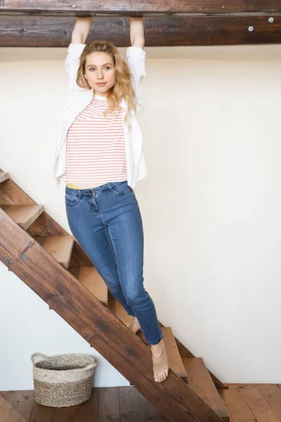 Gadis pirang santai berdiri di tangga kayu — Stok Foto
