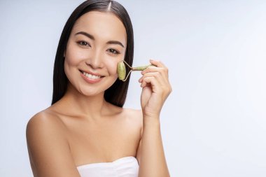 Kamerada poz veren uzun saçlı esmer kadın.