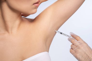 Professional cosmetologist doing armpit botox for client