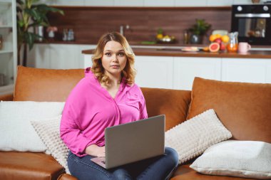 Attractive curly haired woman using her computer