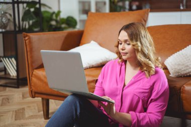 Beautiful girl smiling while looking at laptop