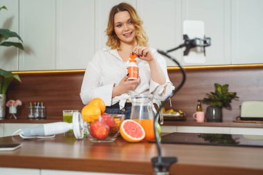 Positive delighted young woman looking at her gadget