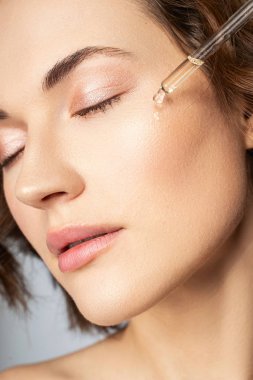 Relaxed brunette female person doing beauty procedures