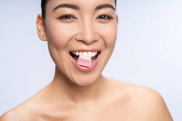 Delighted brunette woman keeping bubble gum in teeth — Stok fotoğraf