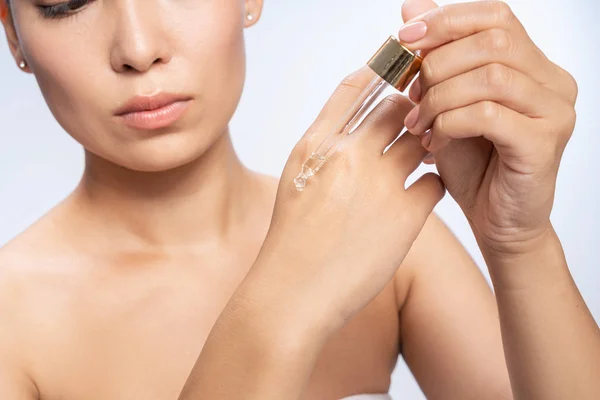 Серйозна жінка тестує олію для чутливої шкіри — стокове фото