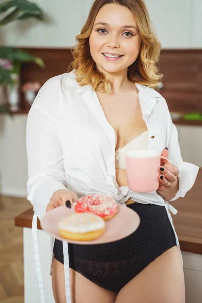 Attractive young female person demonstrating colorful donuts — ストック写真