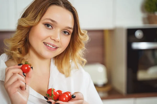 Menina cabelo encaracolado bonito segurando tomates cereja — Fotografia de Stock