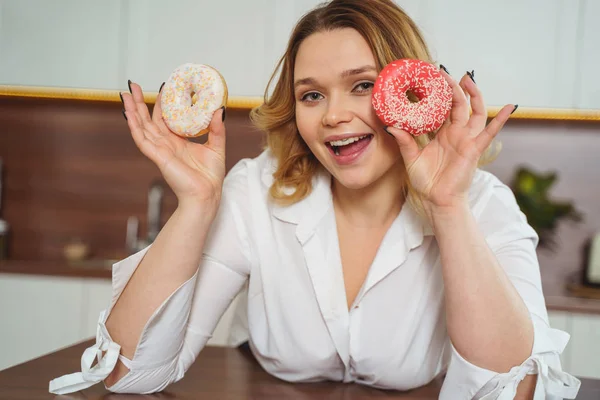 Cheerful female person posing with colorful donuts — Stok fotoğraf