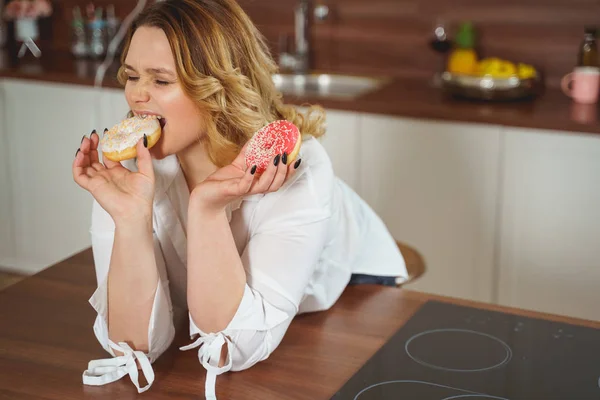 Bonito mulher mordendo donut com prazer — Fotografia de Stock