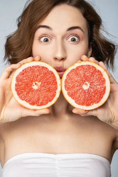 Veselá brunetka dívka pózuje s šťavnatým grapefruitem — Stock fotografie
