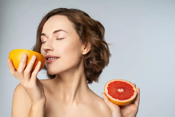 Positive delighted young woman enjoying citrus aroma — Stok fotoğraf