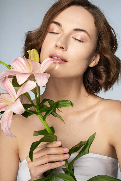 Charming brunette girl smelling her favorite flowers — Stok fotoğraf